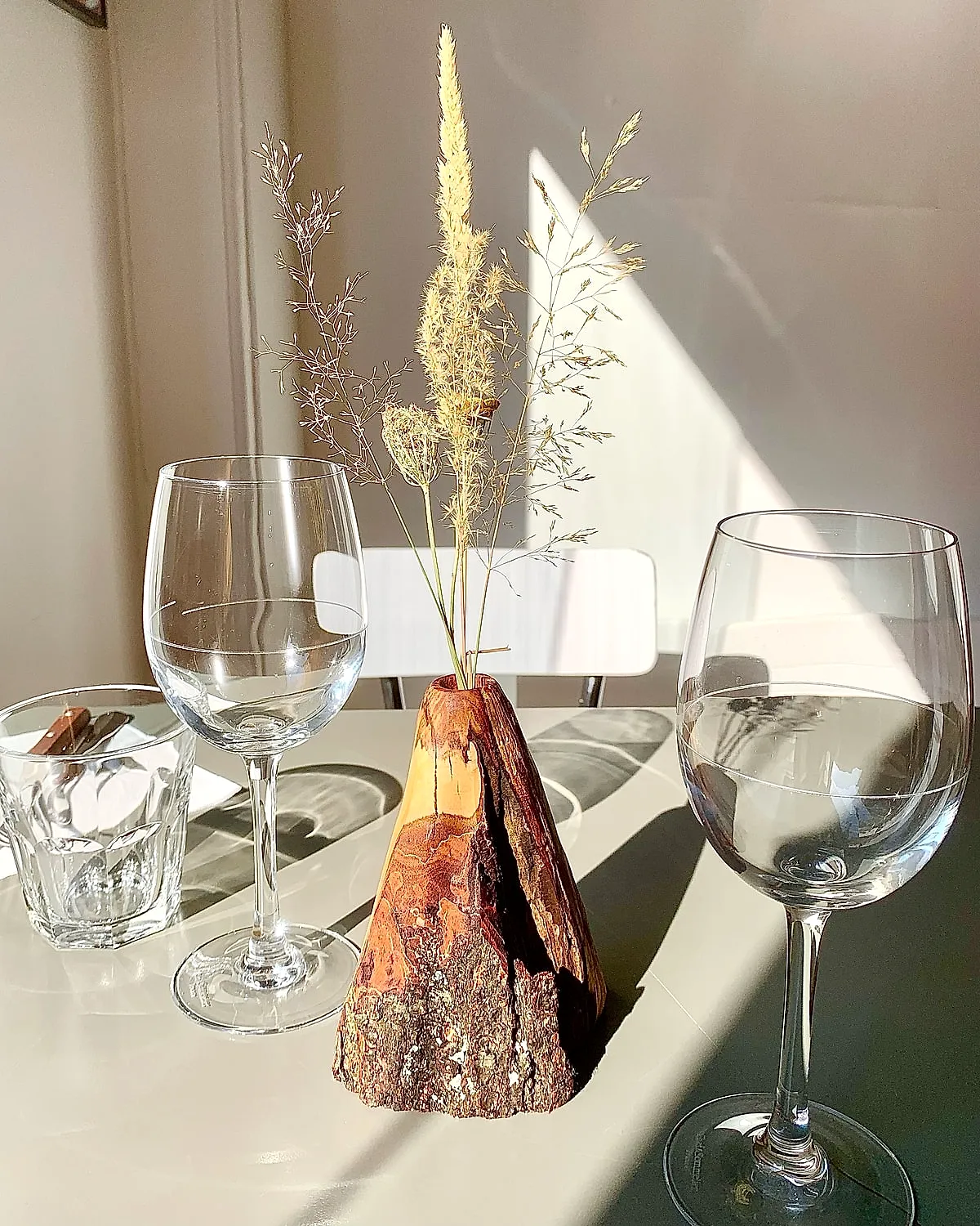 Soliflore en bois et fleurs séchées sur une table dressée