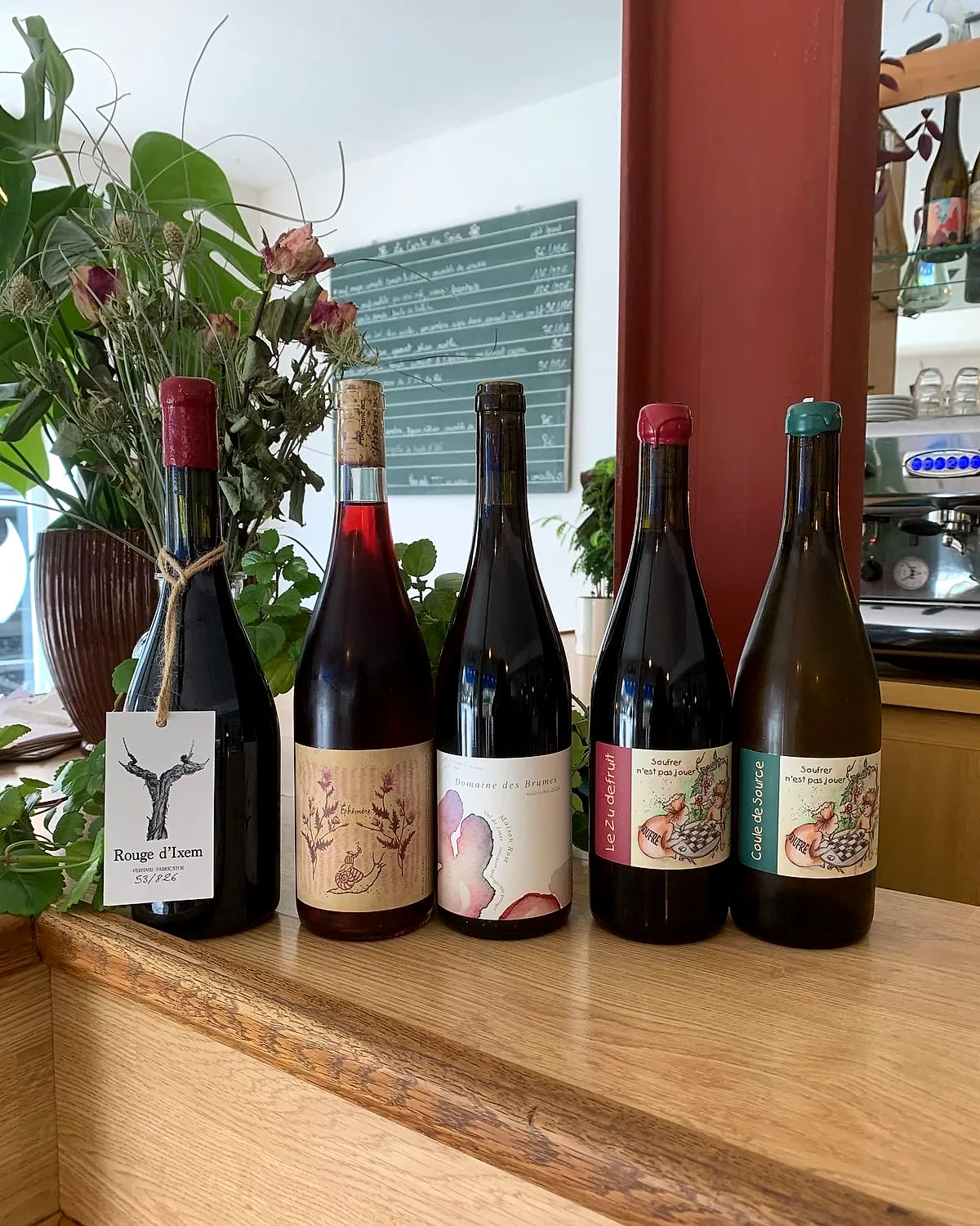 Bouteilles de vin nature devant le mur rouge